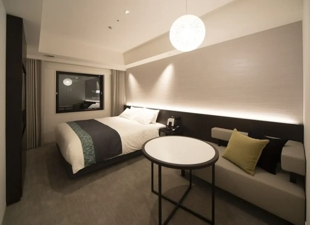 ホテルヴィスキオ大阪の客室写真、ベッドと机がある様子